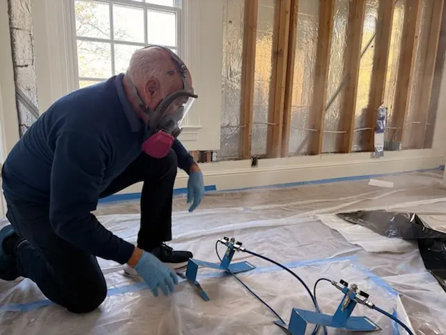 A restoration technician setting drying equipment in an Pearland home stripped to the studs