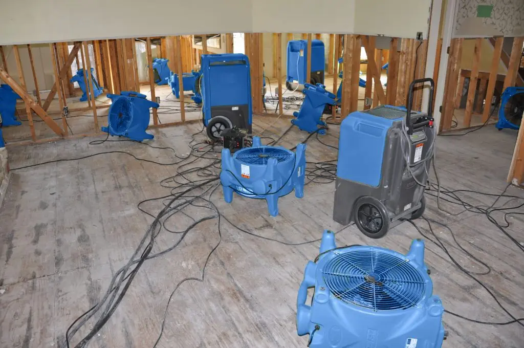 Air movers drying a gutted Pearland room after major water damage